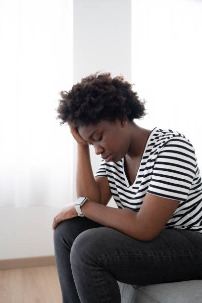 istock Sad black woman sitting on couch 1475063872