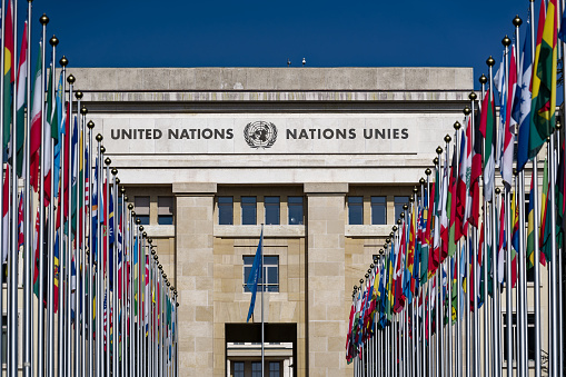 Palace of European headquarters of United Nations UN at Swiss City of Geneva with national flags on a sunny winter day. Photo taken March 5th, 2023, Geneva, Switzerland.