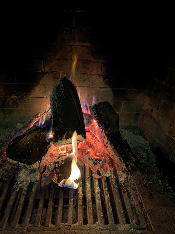 Wood burning in the fireplace in the house at night. Taken on mobile device. iPhone 11.