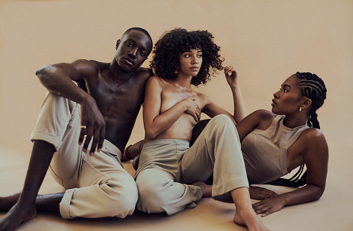 Full body portrait of attractive models with diverse skin tones posing for beauty, skin and makeup. Studio portrait against light brown background.