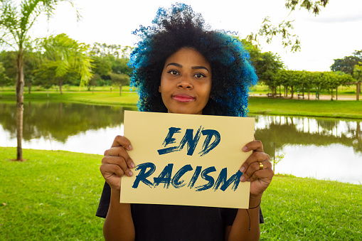 Goiania, Goias, Brazil – March 21, 2023: A young woman, with dyed blue hair, holding a sign with the text: \