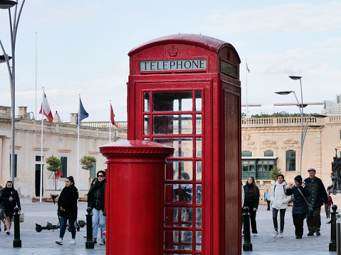 Traditional British red phone booth in the city centre of Valletta.\nValletta, Malta - 06 March 2023