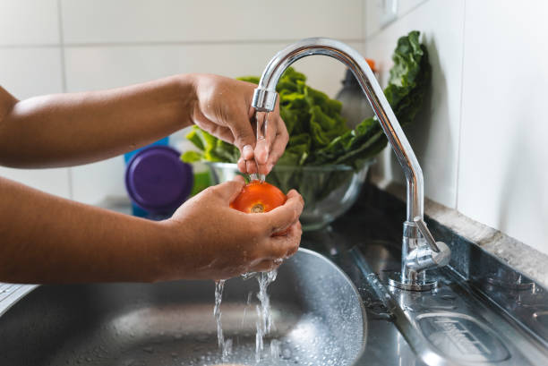 istock Female hand washing vegetables and sanitizing 1475076120