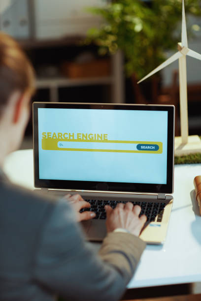 istock Seen from behind modern woman with laptop using search engine 1475076374