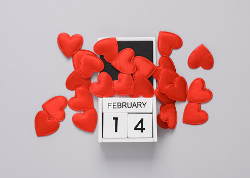 February 14 wooden calendar with hearts on a gray background. Valentine's Day