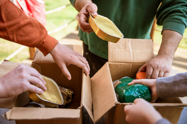 persone che raccolgono prodotti alimentari nella scatola delle donazioni - community outreach social worker teenager poverty foto e immagini stock