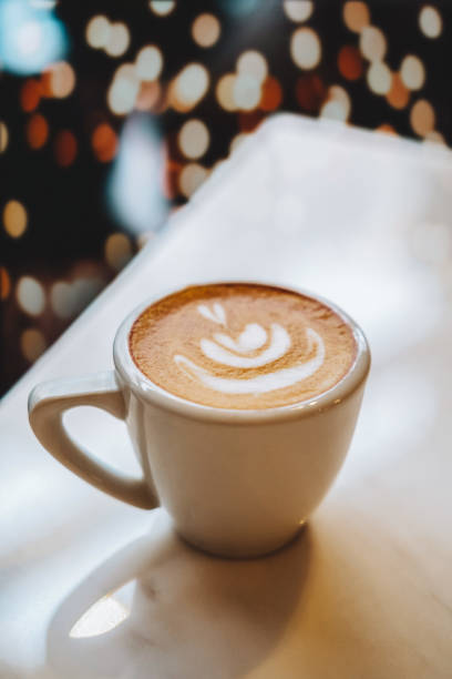 istock Close up selective focus coffee cup with latte art on dark background with bokeh. 1475078042