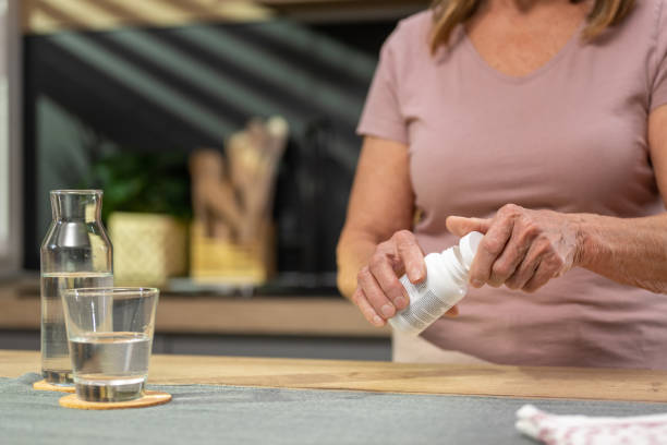 mujer sosteniendo la botella de píldora - opening bottle pill bottle pill fotografías e imágenes de stock