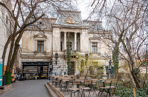 Bucharest, Romania. March 12, 2023: Empty cafe seating outside Palatul Monteoru in Bucharest, a historic landmark.