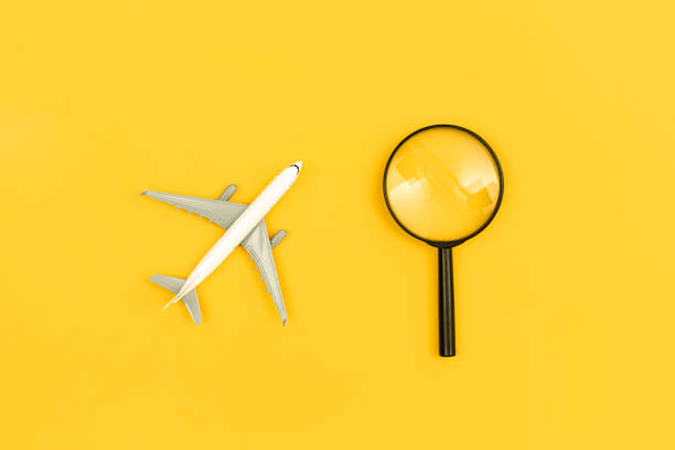 istock Airplane model and magnifier on yellow background, flat lay. 1475090352