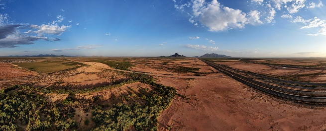 Aerial panoramic image of Interstate 10, Picacho Peak in the distance, and the grandeur of the Sonoran Desert on a summer morning.