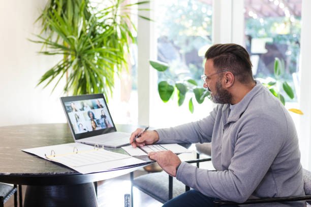 istock Businessman attends meeting from home with diverse co-workers 1475093230