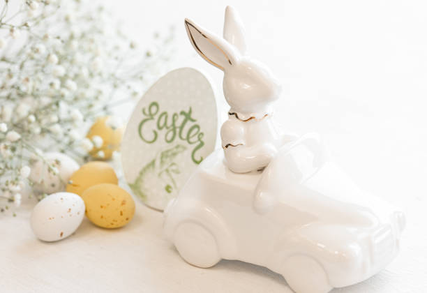 istock Easter background with a ceramic hare in the car and eggs on a white background, 1475093835