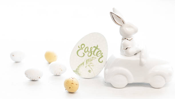 istock Easter background with a ceramic hare in the car and eggs on a white background, 1475093842