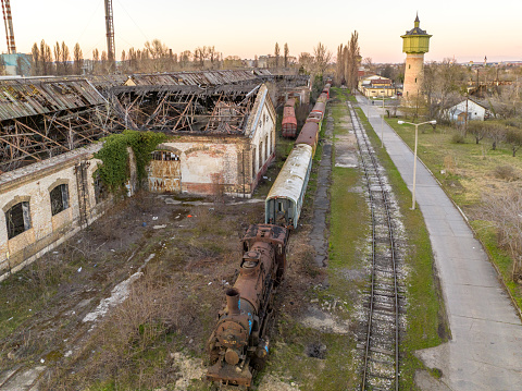 Color image depicting an old train carriage that has been abandoned on the railroad track and left to rust and ruin.