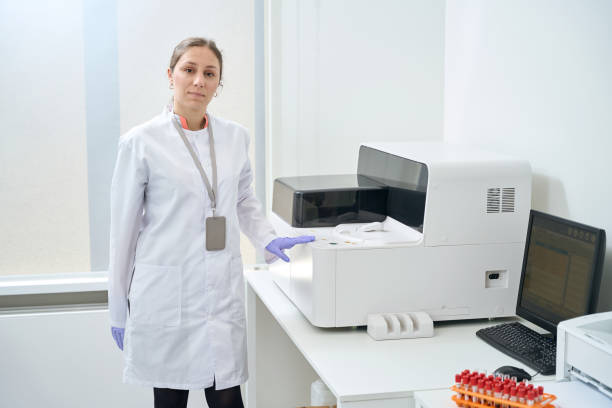 istock Female geneticist stands near an immunochemiluminescent analyzer 1475094481