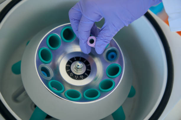 l'uomo mette una provetta con biomateriale nella centrifuga ematologica - blood blood sample blood donation tube foto e immagini stock