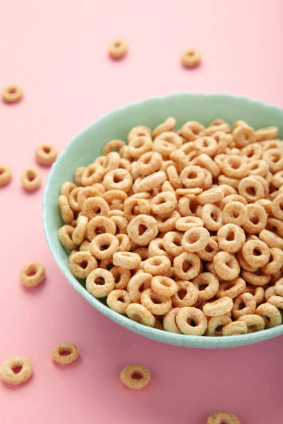 istock Bowl of sugar-coated corn flakes on pink background. 1475094692