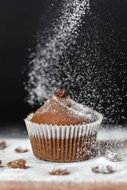 istock Fresh muffin sprinkled with powdered sugar on a black background 1475094978