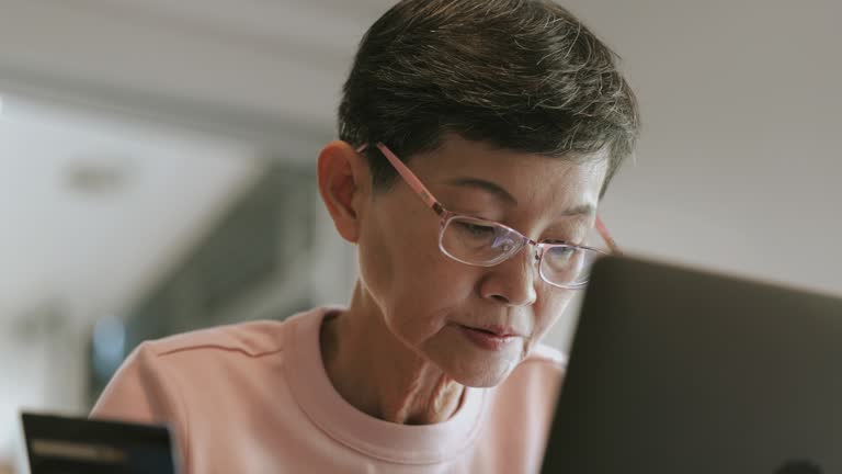 Senior adult woman trying to using her credit card with online shopping