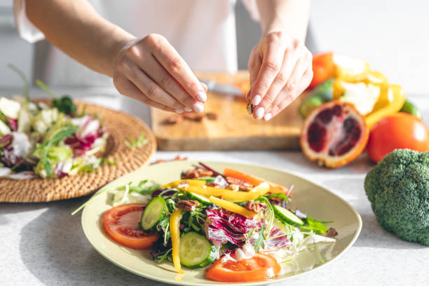 istock A woman makes a fresh vegetable salad, close-up. 1475102056