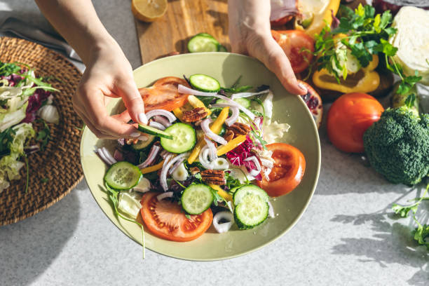 istock A woman makes a fresh vegetable salad, close-up. 1475102064