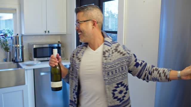 Asian Gay Man Takes Bottle of Wine While Cooking With Partner