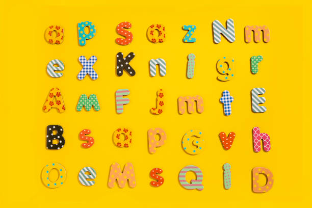 istock Many multi-colored letters of the alphabet on a yellow background. Top view, flat lay 1475104214