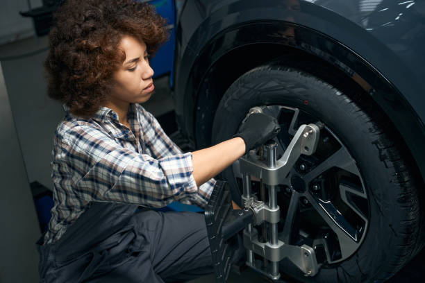 istock Woman auto mechanic performs wheel balancing, adjusts wheel alignment 1475104382