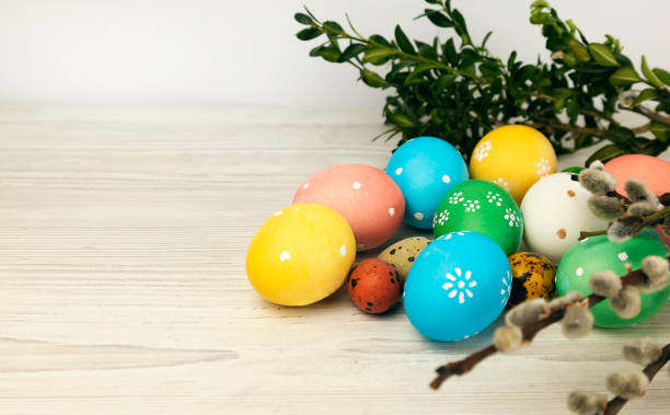 istock Colored Easter eggs with willow twig and green leaves isolated on white background. 1475104608