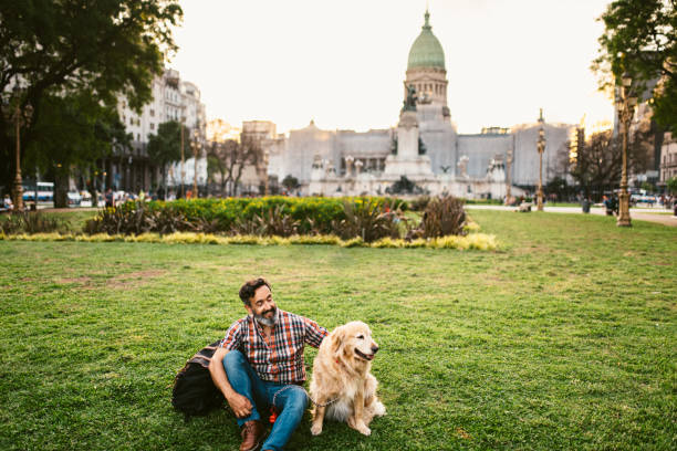 istock Golden retriever and owner sitting on the grass 1475104816