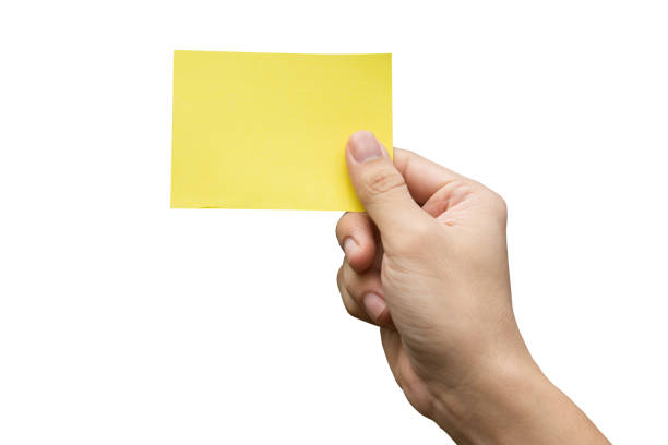 istock Hand holding yellow paper isolated on white 1475106532