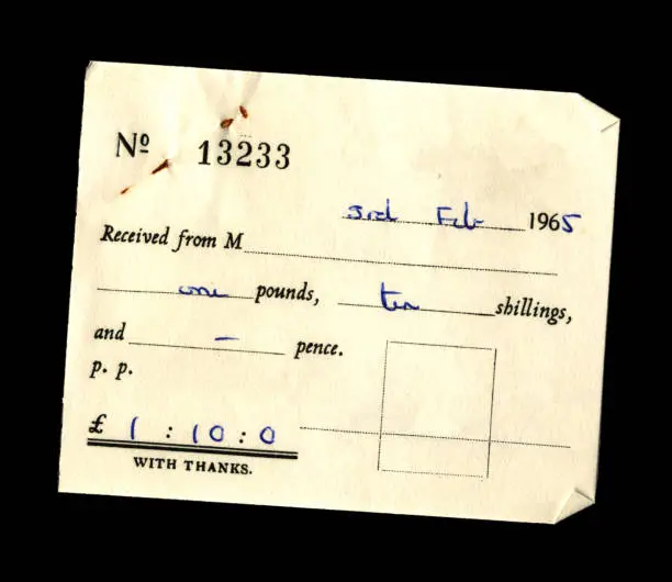 Small generic British receipt on a black background, dated 1965 and for the sum of £1.10s.0d. At some point, the receipt has been fastened to another paper with a pin which, over time, has become rusty and left rust stains on the receipt. (All identifying details have been removed.)