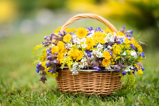 Bouquet of flowers in the basket on grass