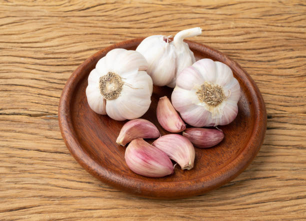 istock Garlic bulb and cloves on a plate over wooden table 1475107820