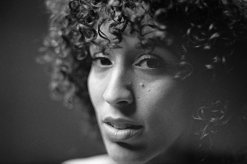 A portrait of a multiracial woman in a studio. Taken on 35mm black and white film and scanned.