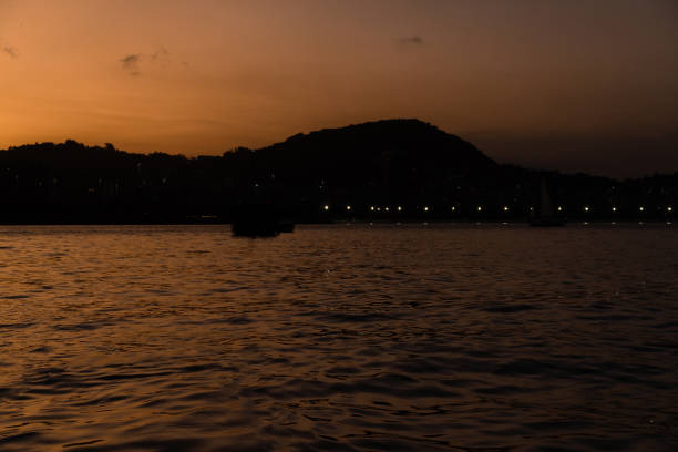 закат в бухте гуанабара, бухта и пляжи рио-де-жанейро, бразилия с ее зданиями, лодками и ландшафтом. отражение неба в море - flamengo стоковые фото и изображения