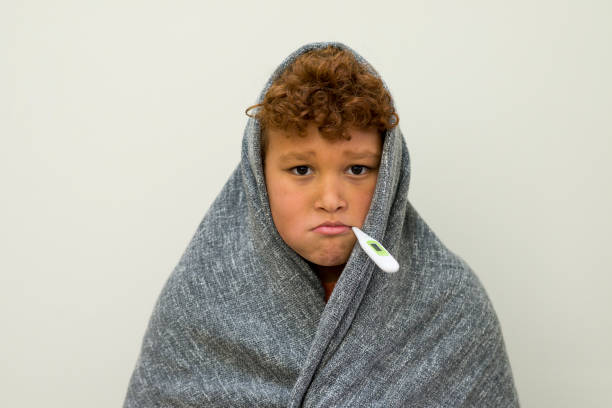 istock Sick Boy Getting His Temperature Taken 1475114296