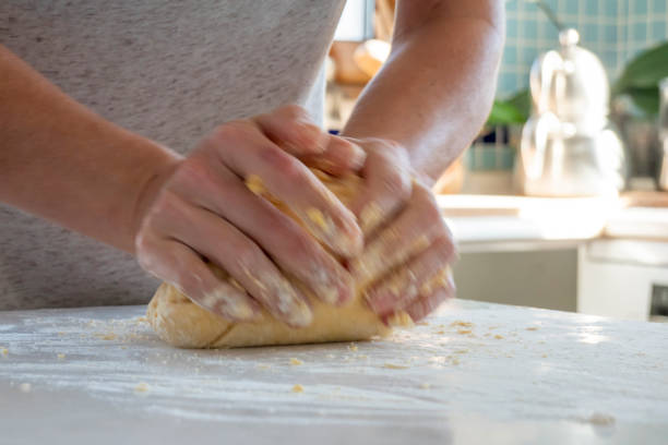 istock Woman kneading dough on kitchen counter 1475114434