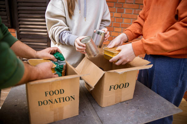 confezionare il cibo in scatole per le donazioni per beneficenza - community outreach social worker teenager poverty foto e immagini stock
