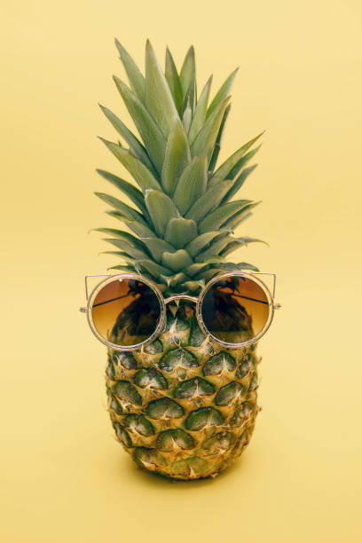 istock Pineapple in sunglasses on a yellow background 1475116346