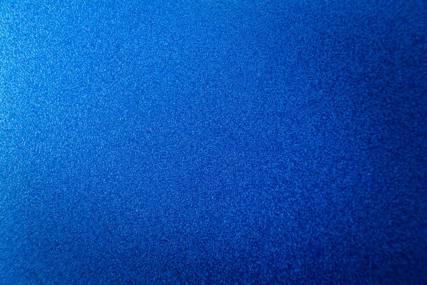 istock Blue abstract surface with grainy texture. A blue matte background with focus in the middle and blurring at the top and bottom. 1475117228