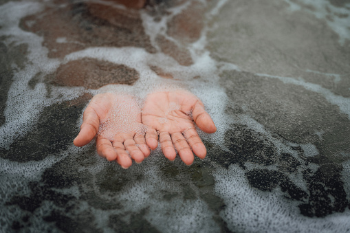 Close up of hands moving gently through bubbling, hot tub water
