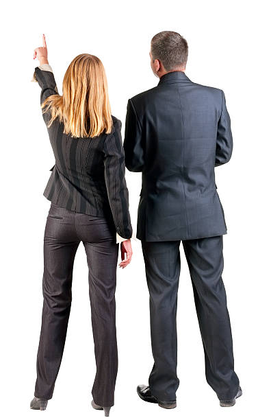 Two business people facing away while the woman points Back view of  pointing business team. young couple (man and woman) .  beautiful friendly girl and guy in suit together. Rear view people collection.  backside view of person.  Isolated over white background. man touching womans buttock stock pictures, royalty-free photos & images