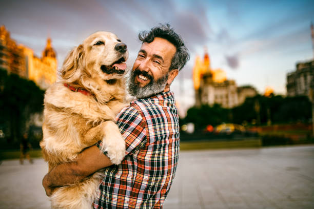 istock Mature man hugs golden retriever 1475121295