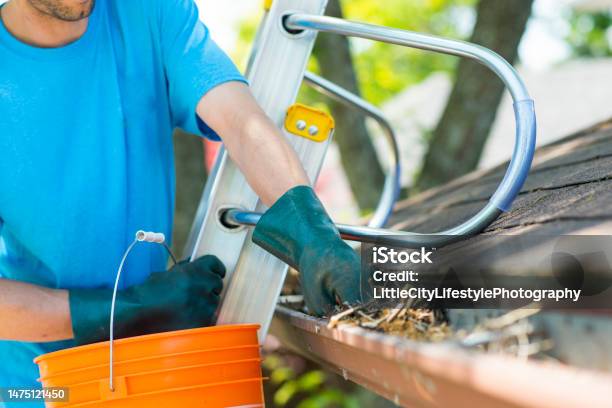 Maintaining The House Includes Eavestrough Cleaning Stock Photo - Download Image Now