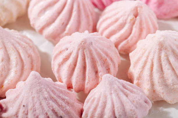 istock Pink meringue cookies with berry flavor on baking parchment 1475121532