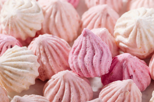 istock Pink meringue cookies with berry flavor on baking parchment 1475121538