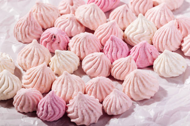 istock Pink meringue cookies with berry flavor on baking parchment 1475121539