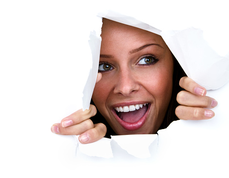Happy young woman ripping through white paper 